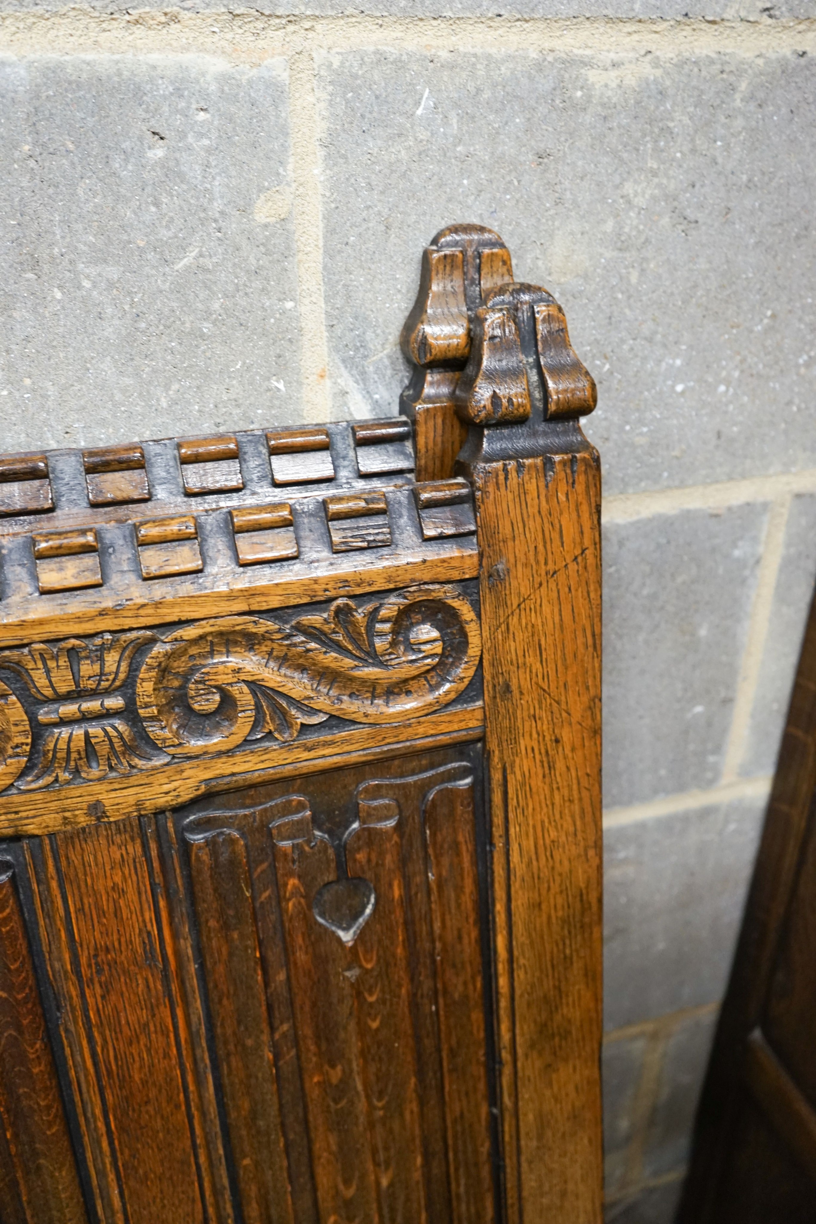 A 17th century style carved and panelled oak triple wardrobe with linenfold decoration, and a pair of early 20th century revival linenfold carved single bedframes, width 91cm, height 130cm